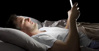 Man som surfar på en iPad i sängen