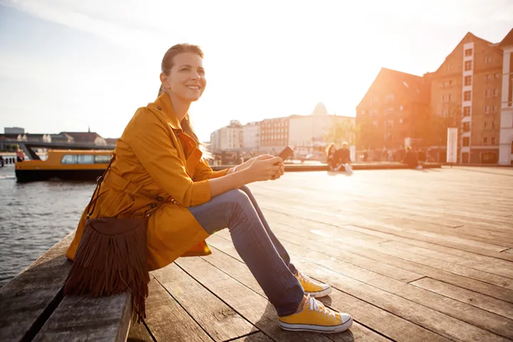 Woman in city enjoyng sun.