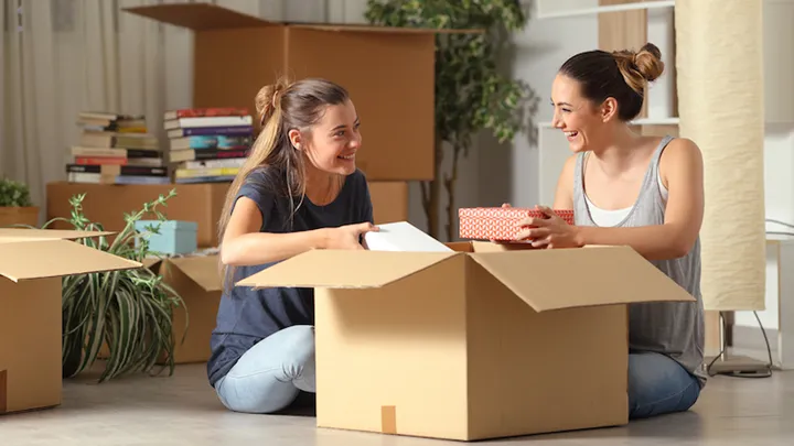 Roommates talking unboxing gelongings moving home