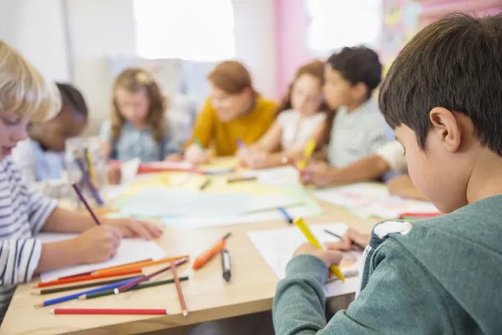 Teacher and students drawing in classroom
